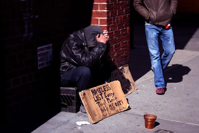 An unhoused man on a sidewalk in New York City.